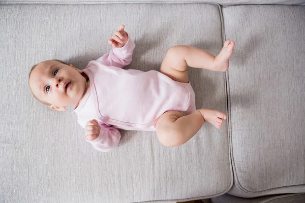 Baby lying on sofa in living room — Stock Photo, Image