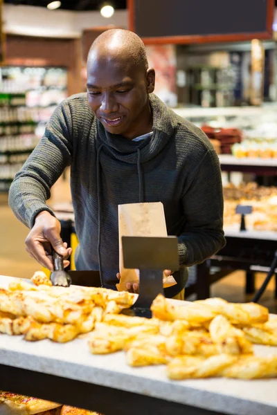 Un homme souriant achète du pain — Photo