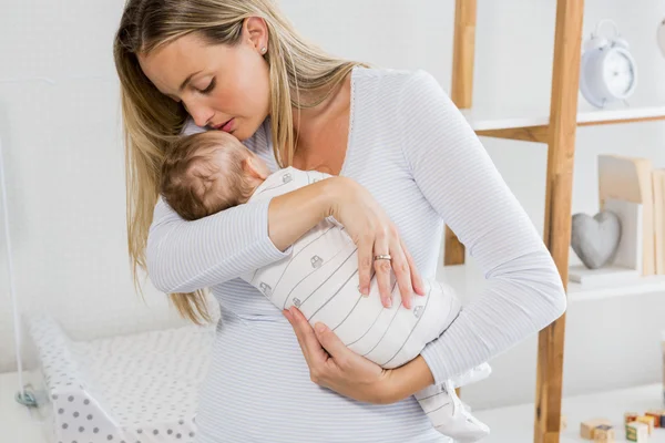 Mãe segurando e beijando seu menino — Fotografia de Stock