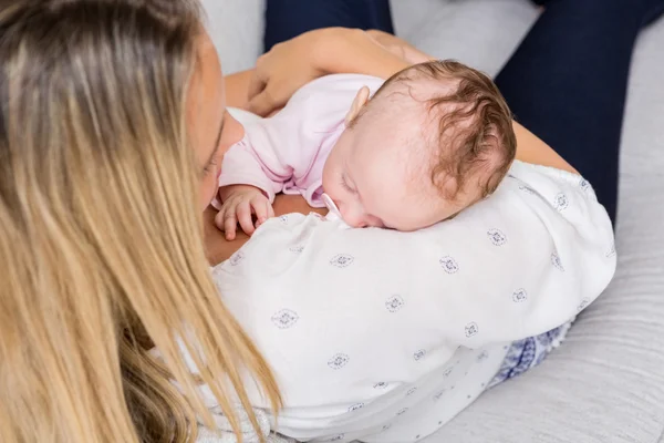 Mutter trägt ihr Baby im Wohnzimmer — Stockfoto