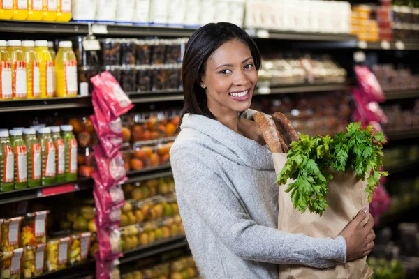 Mujer sonriente sosteniendo una bolsa de supermercado —  Fotos de Stock