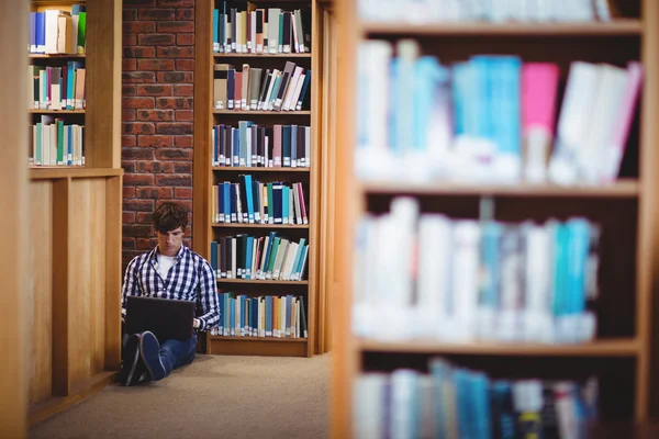 Uczeń korzysta z laptopa w bibliotece — Zdjęcie stockowe