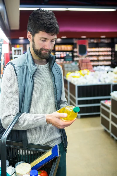 Mann mit Ölflasche im Einkaufskorb — Stockfoto