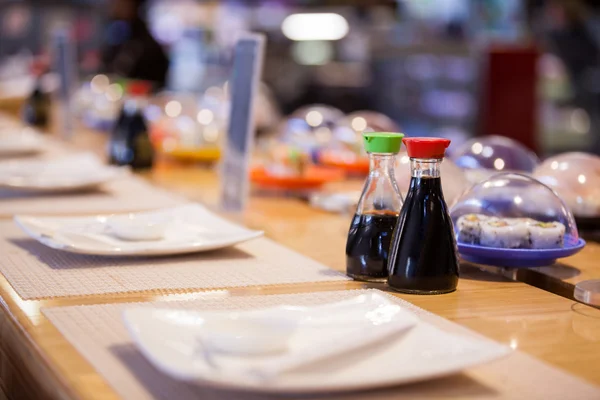 Соусы и суши на столе — стоковое фото