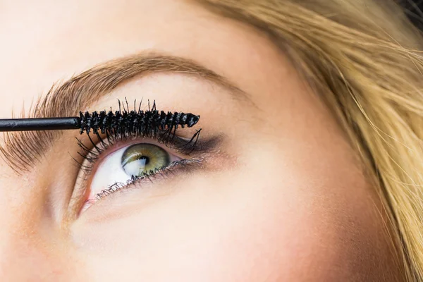 Woman applying mascara on eyelashes — Stock Photo, Image