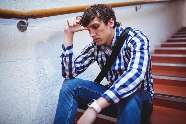 Upset student sitting on staircase — Stock Photo, Image