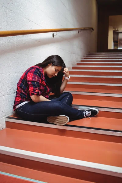 Zdenerwowany kobiet student siedząc na schodach — Zdjęcie stockowe