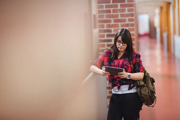 Kobiet student za pomocą tabletu w korytarzu — Zdjęcie stockowe