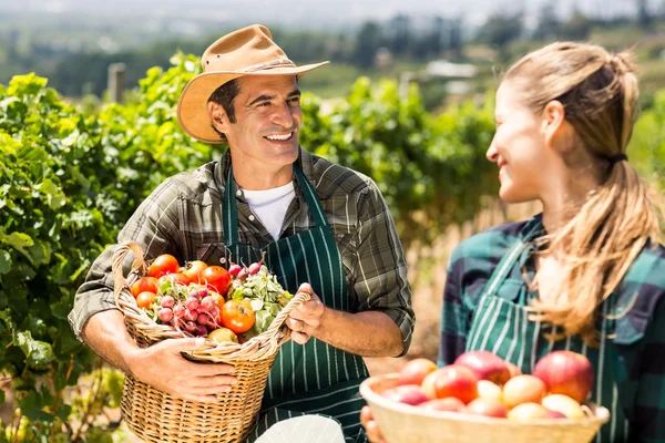 Farmer couple holding baskets — Stock Photo, Image