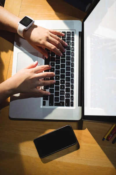 Vrouwelijke student via laptop in bibliotheek — Stockfoto