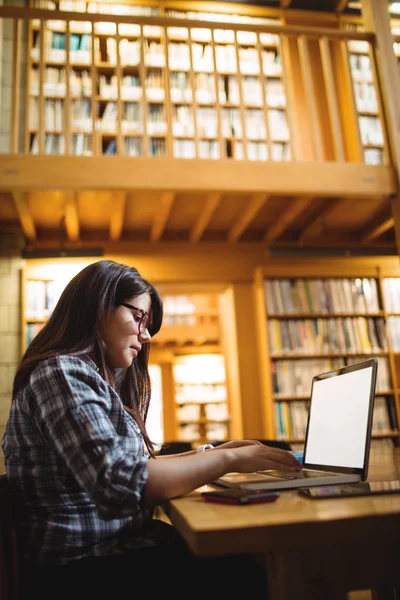 Kobiet student korzysta z laptopa w bibliotece — Zdjęcie stockowe