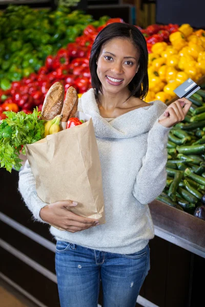 Žena držící kreditních karet a pytel s potravinami — Stock fotografie