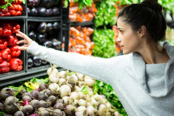 Wanita membeli sayuran di toko organik — Stok Foto