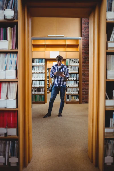 Uczeń za pomocą cyfrowego tabletu w bibliotece — Zdjęcie stockowe