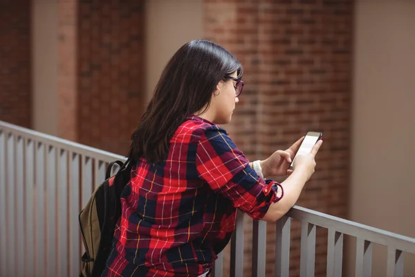 Studentka pomocí telefonu v chodbě — Stock fotografie