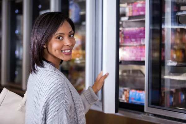 Woman standing near refrigerator Stock Photo