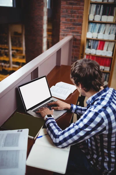 Étudiant utilisant un ordinateur portable dans la bibliothèque — Photo
