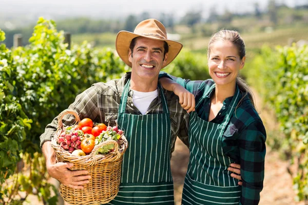 Bauernpaar hält einen Korb mit Gemüse — Stockfoto