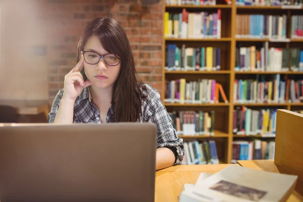 Doordachte vrouwelijke student met behulp van laptop — Stockfoto