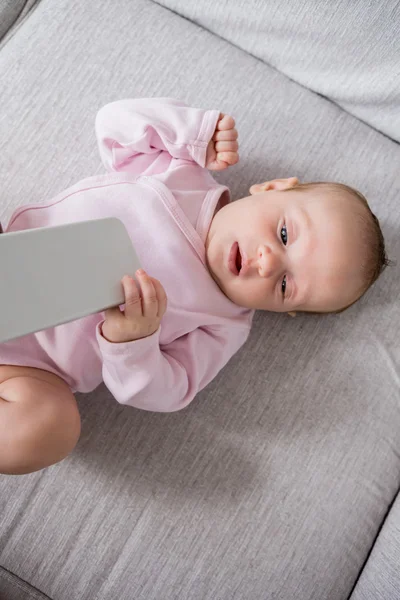 Baby lying on sofa in living room — Stock Photo, Image