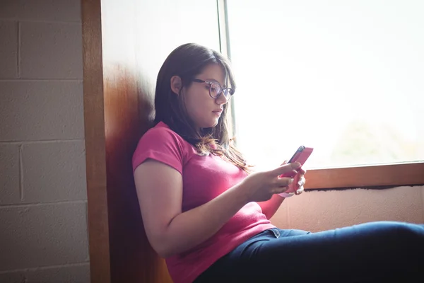 Vrouwelijke student met behulp van mobiele telefoon — Stockfoto