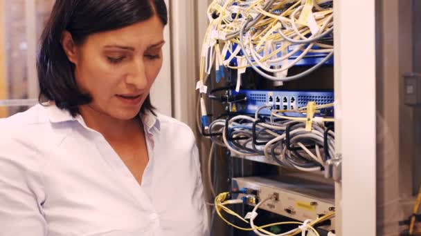 Technician checking cables in a rack mounted server — Stock Video