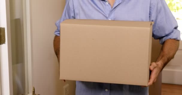 Hombre llevando cajas en casa nueva — Vídeos de Stock