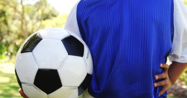 Menino segurando uma bola de futebol no parque — Vídeo de Stock