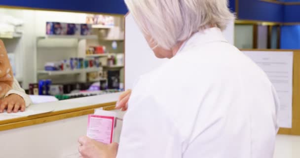 Apotheker hilft dem Kunden bei der Flasche mit dem Medikament — Stockvideo