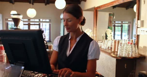 Waitress talking on the phone at counter — Stockvideo