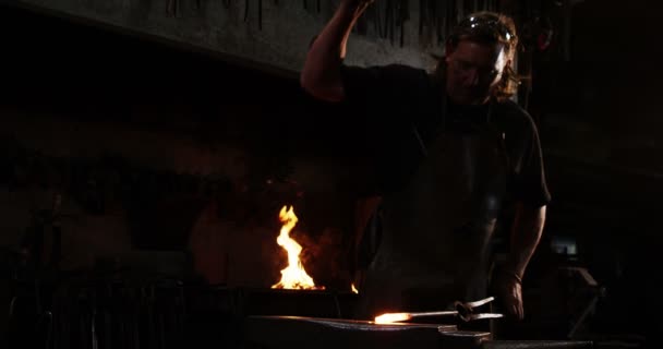 Кузнец, работающий на железном стержне — стоковое видео