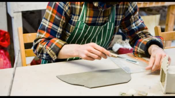 Male potter molding a piece of flat clay — Stock Video