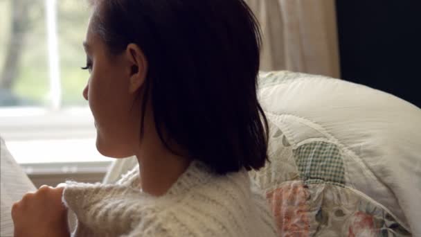 Woman reading novel in bedroom — Stock video