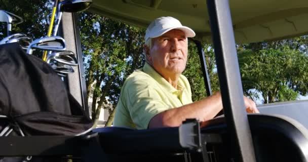 Golfer sitting in golf buggy — ストック動画