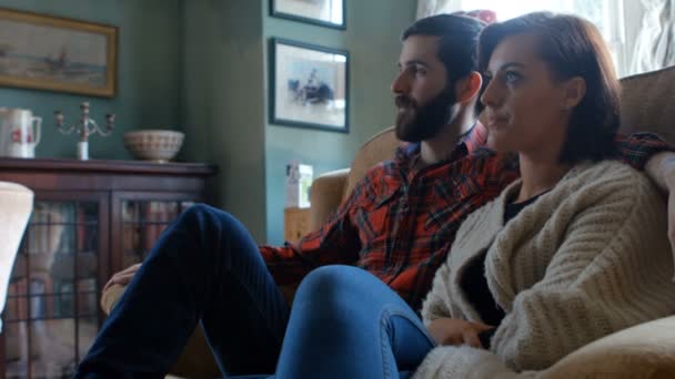Pár sedí na pohovce u televize — Stock video
