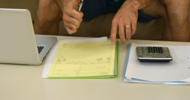 Homme avec ordinateur portable comptabiliser les factures — Video