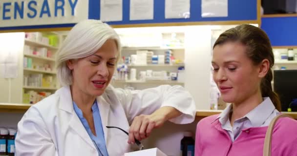 Farmacéutico que ayuda a la botella de medicamento al cliente — Vídeo de stock