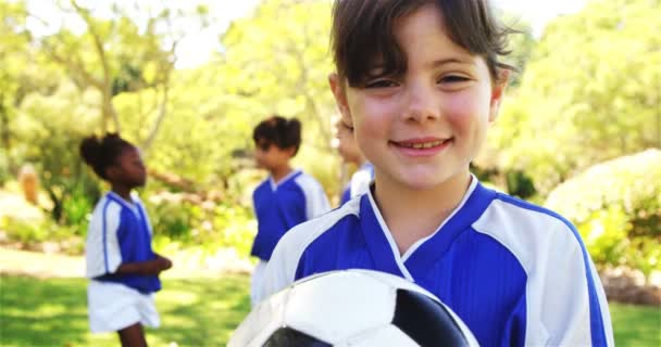 Chica sosteniendo un fútbol en el parque — Vídeos de Stock