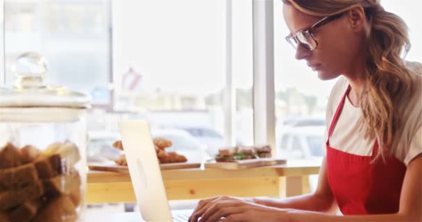 Thoughtful waitress using laptop — Stock Video