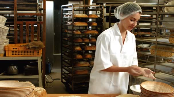 Vrouwelijke bakker kneedt een deeg — Stockvideo