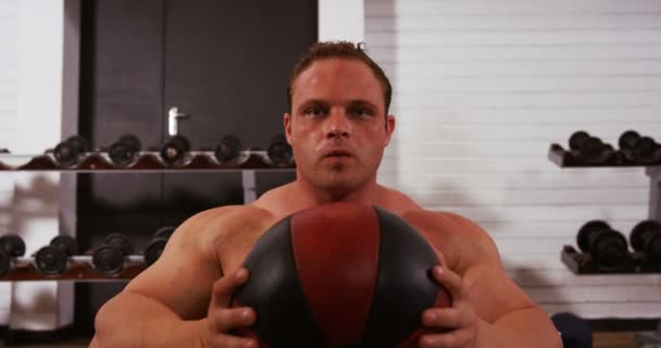 Man doing crunches with ball — Stockvideo