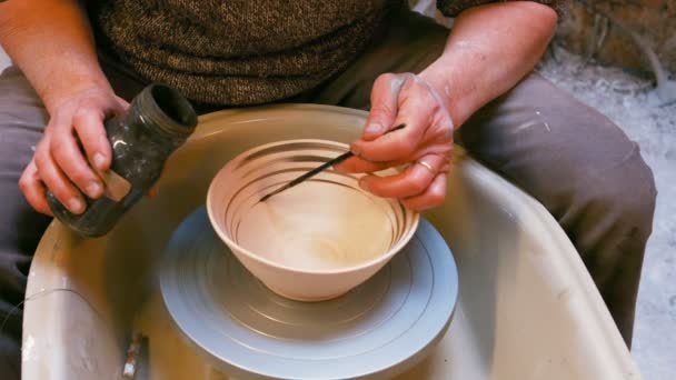 Mannelijke artiest schilderen op aardewerk bowl — Stockvideo