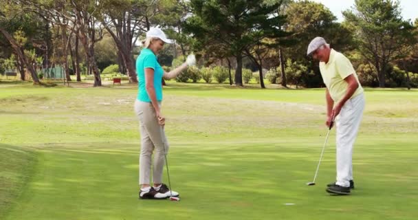 Два счастливых игрока в гольф дают пять — стоковое видео