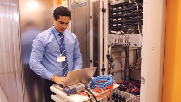 Técnico hablando por teléfono móvil en la sala de servidores — Vídeo de stock