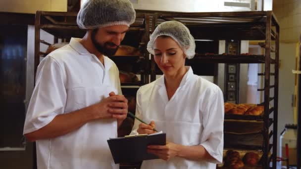 Panaderos manteniendo un registro en el portapapeles — Vídeo de stock