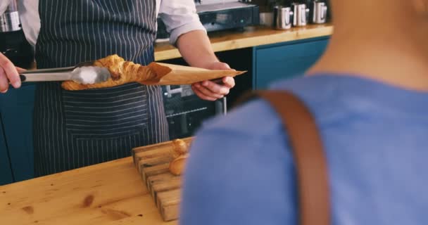 Aitress packning croissanter i papperspåse — Stockvideo