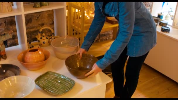 Vrouw kijken naar aardewerken pot — Stockvideo