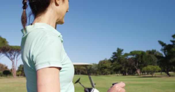 Golfista proteger los ojos mientras está de pie jugando al golf — Vídeos de Stock