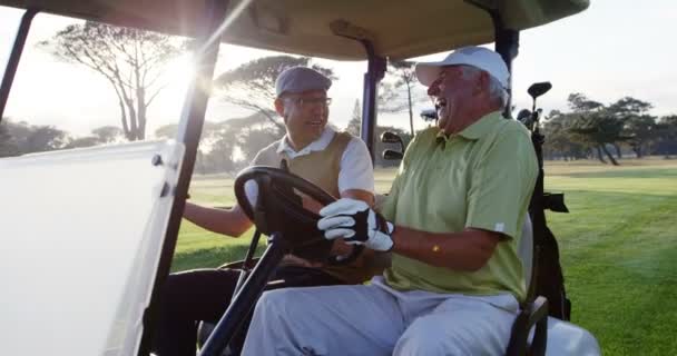 Golfers laughing together in their golf buggy — Stockvideo