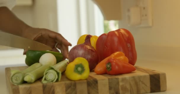 Mujer picando verduras en la cocina — Vídeo de stock